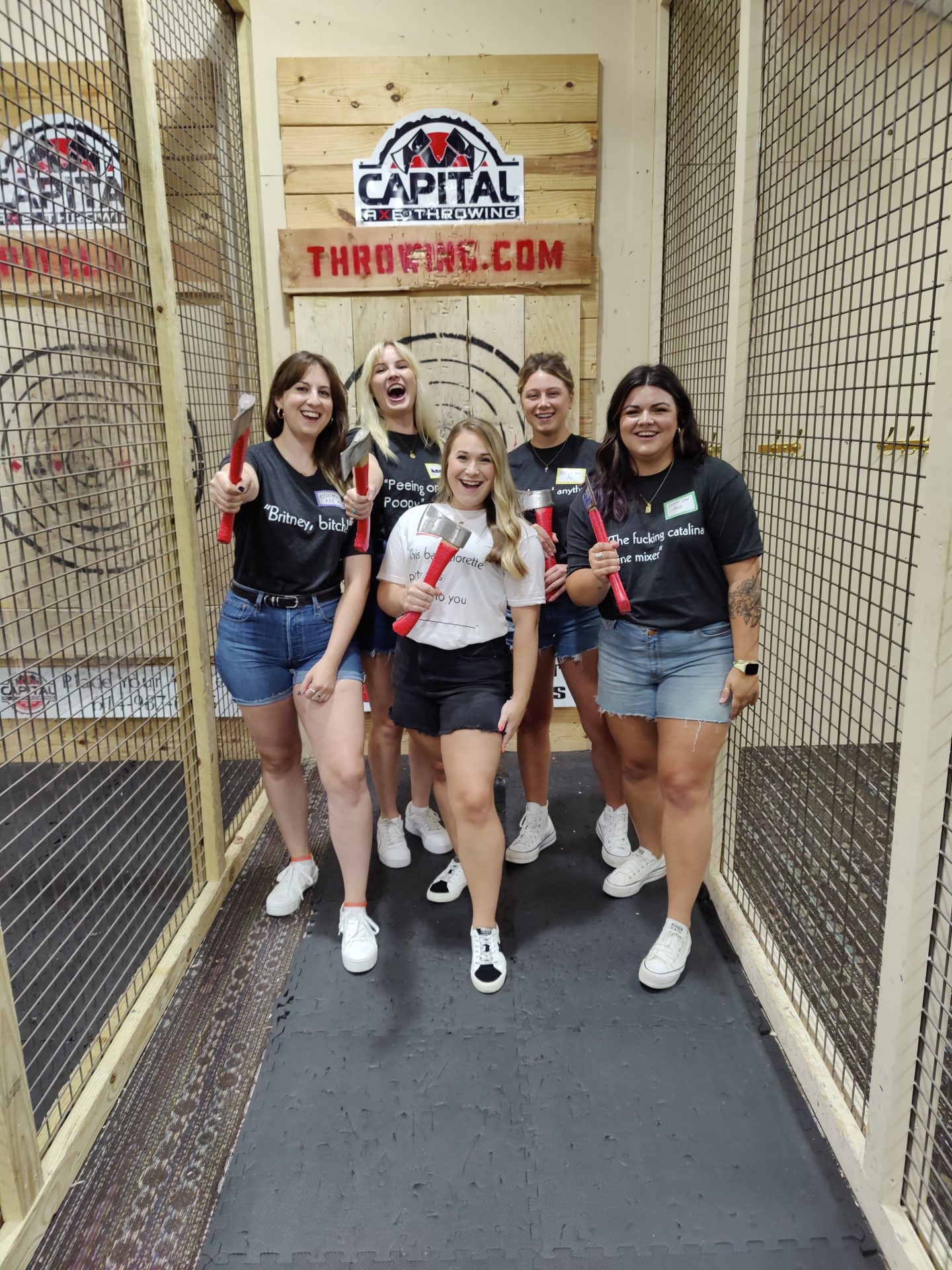 Bachelorette party group holding axes at Capital Axe Throwing